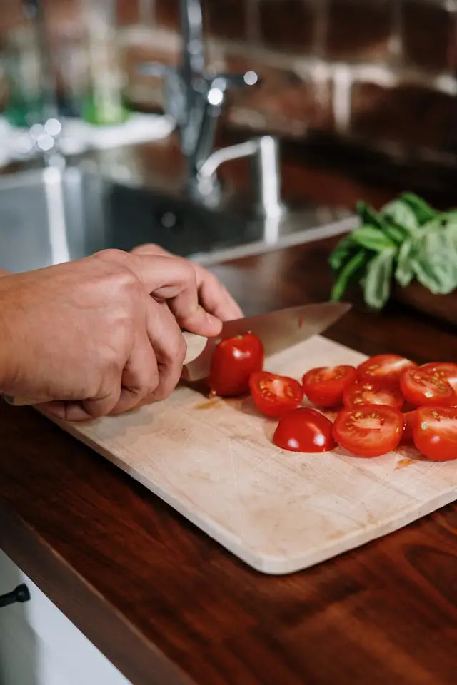 Sobre Nosotros: Picando tomates sobre una tabla