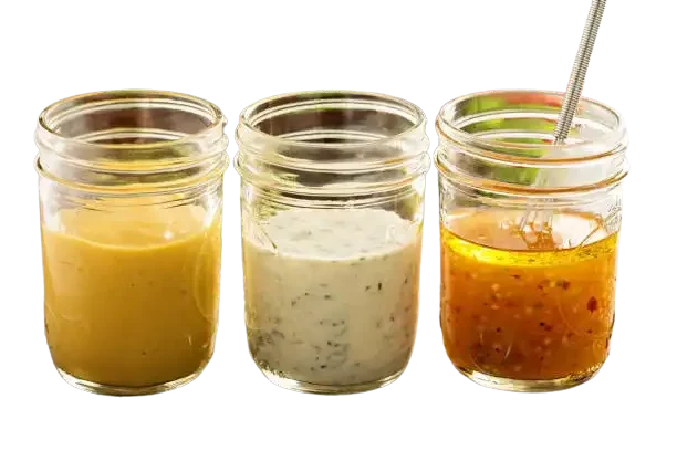 Tres tarros con diferentes aliños para ensaladas con frutas