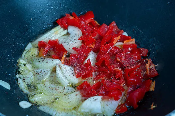 Preparando un sofrito de cebolla y pimiento rojo para elaborar potajes