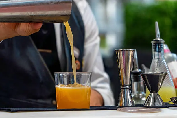 vertiendo un móctel sin alchohol en un vaso