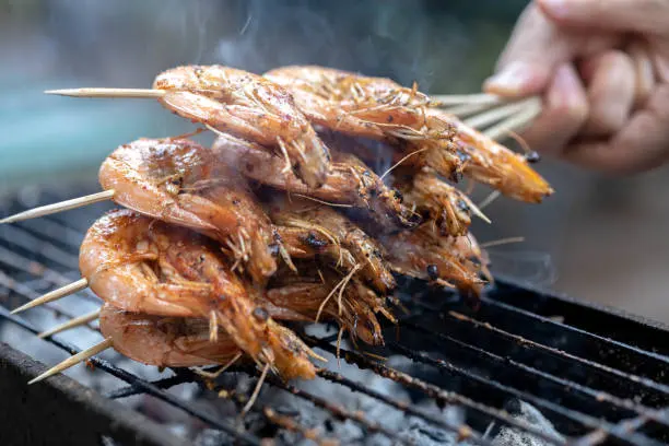 Asando gambas en una barbacoa
