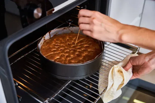 Pinchando el bizcocho con un palillo para comprobar si ya está hecho