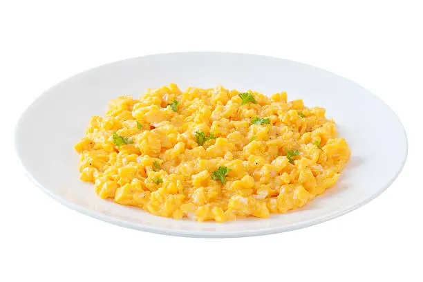 Un plato con huevos revueltos y un poco de perejil