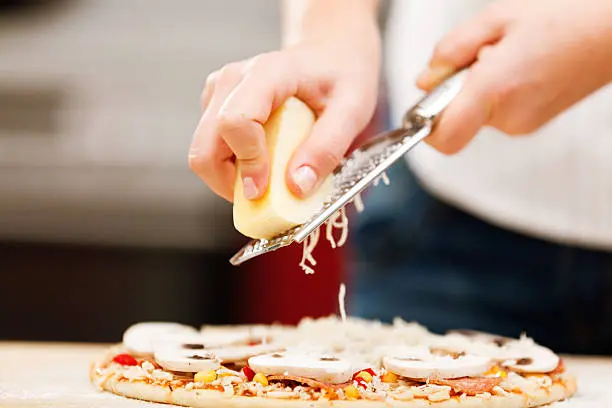 Rallando queso sobre una pizza