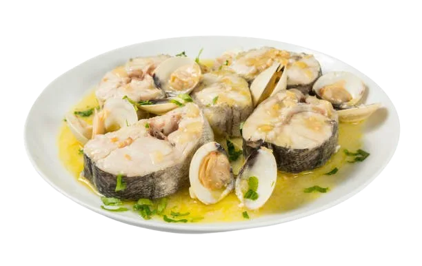 Un plato de merluza con almejas y salsa verde